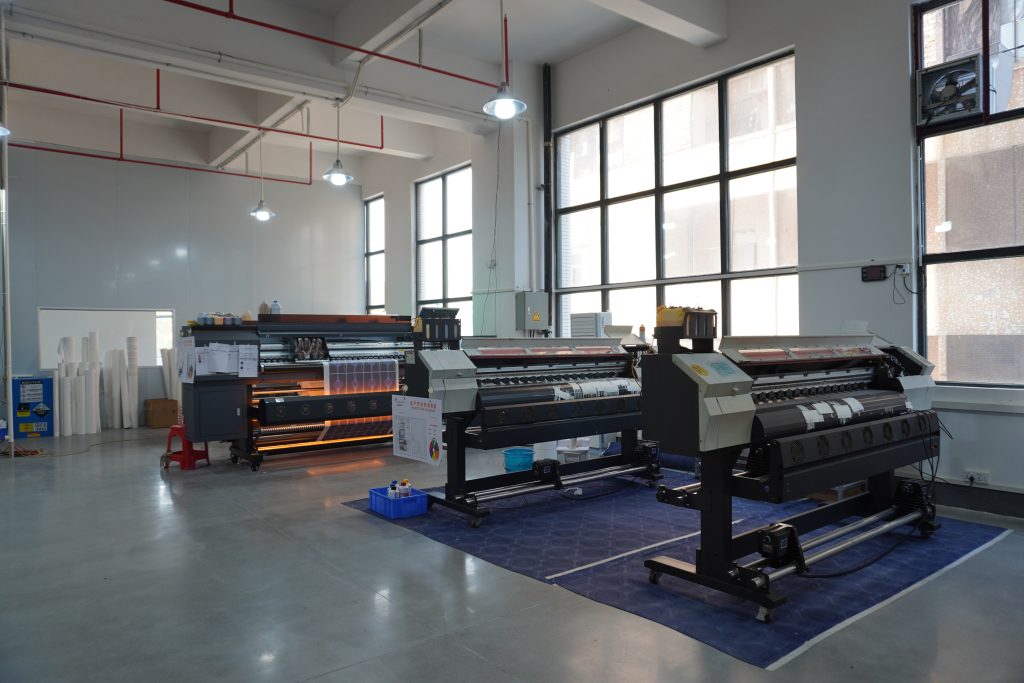 Large-format digital printing machine for custom mouse pad designs in professional manufacturer's workshop.