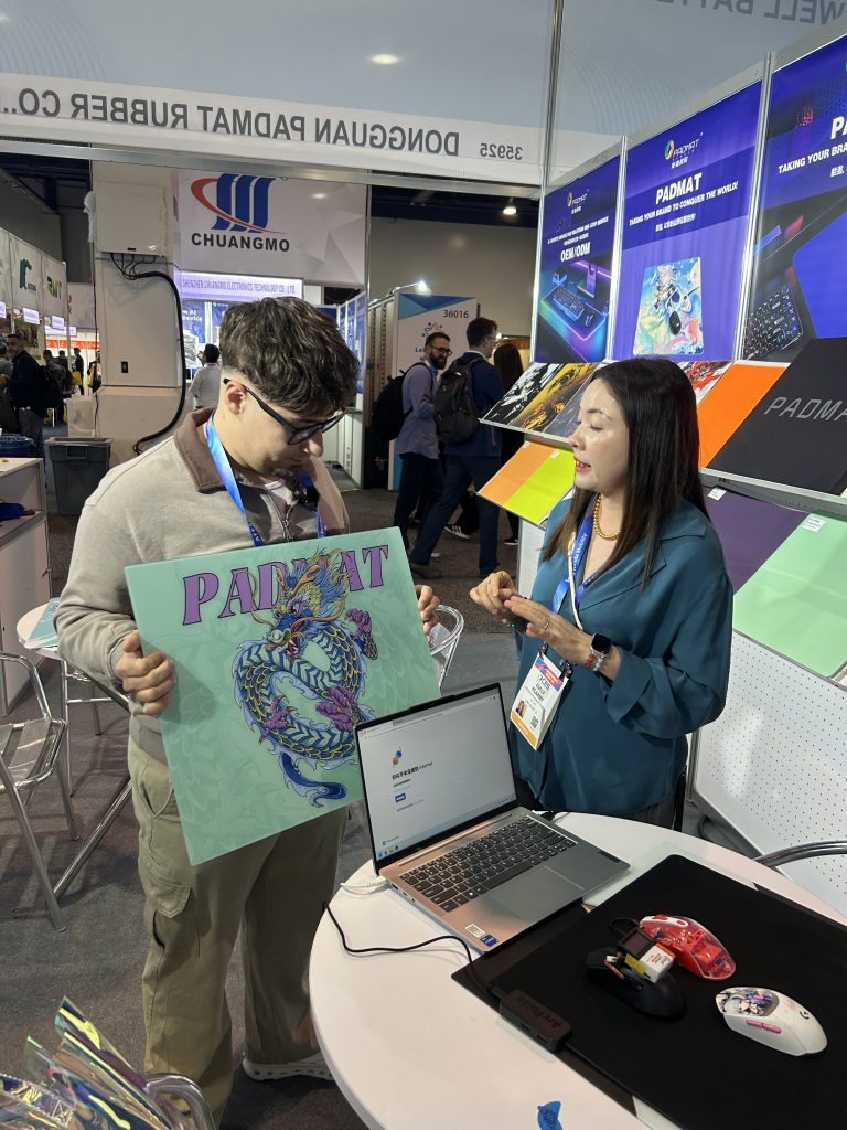 Padmat Rubber presenting a custom printed mouse pad sample to an international client at CES 2026 Las Vegas